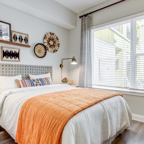 Vinyl flooring in bedroom with large window and bed